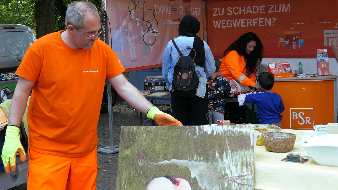 BSR-Mitarbeiter sortiert abgegebene Gegenstände an einem Kieztag-Stand