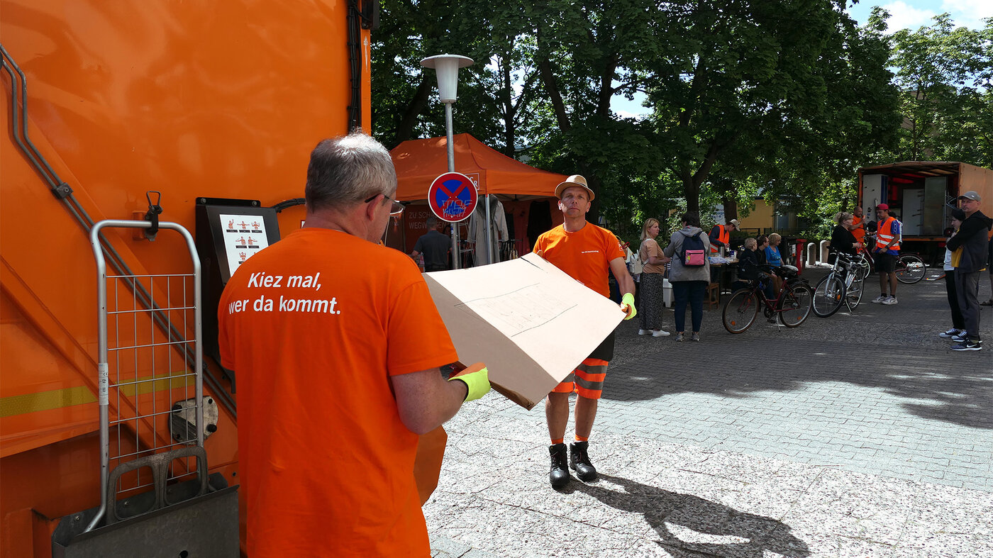 BSR-Mitarbeitende nehmen bei einem Kieztag Sperrmüll an einem Entsorgungsfahrzeug entgegen